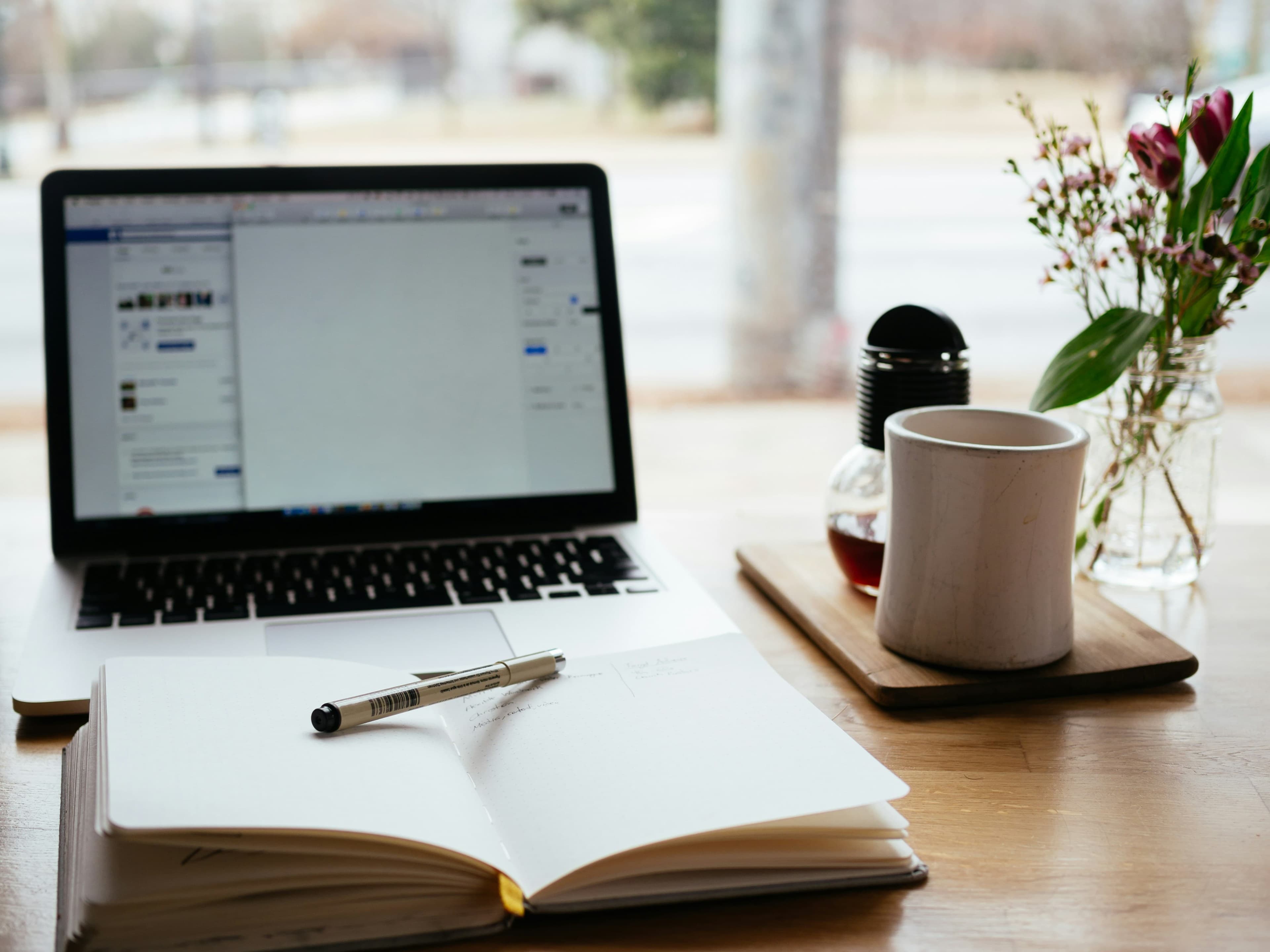 Person writing social content strategy on a laptop