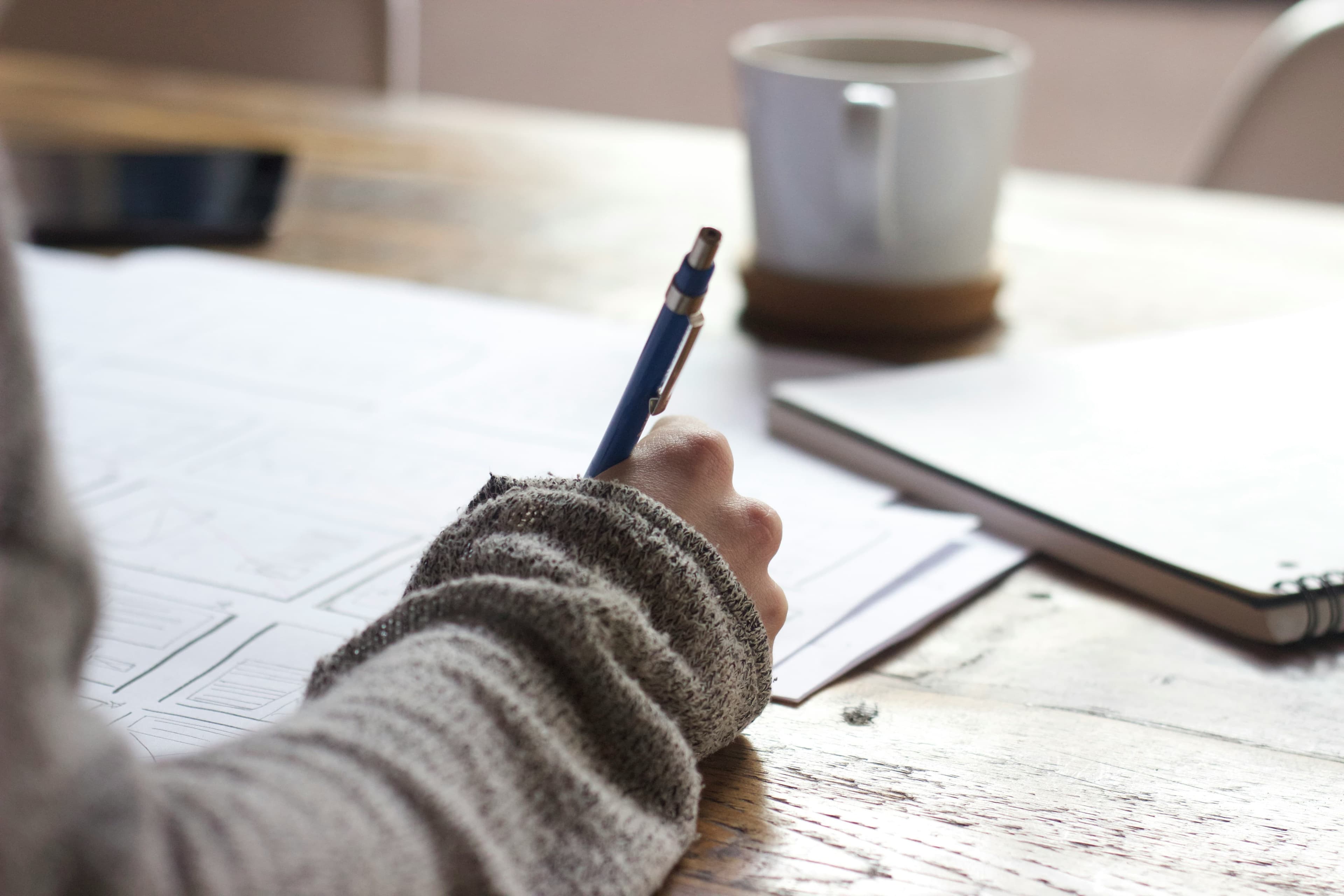 Person brainstorming content ideas on a notepad